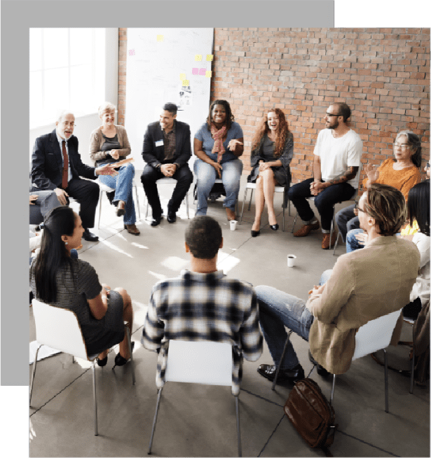 A group of people sitting in chairs around each other.