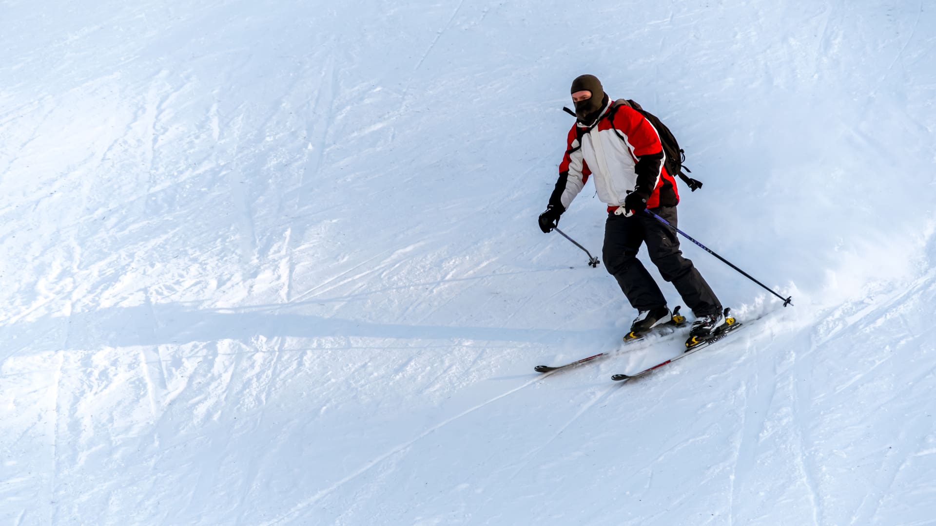 A man riding skis on top of snow covered slope.