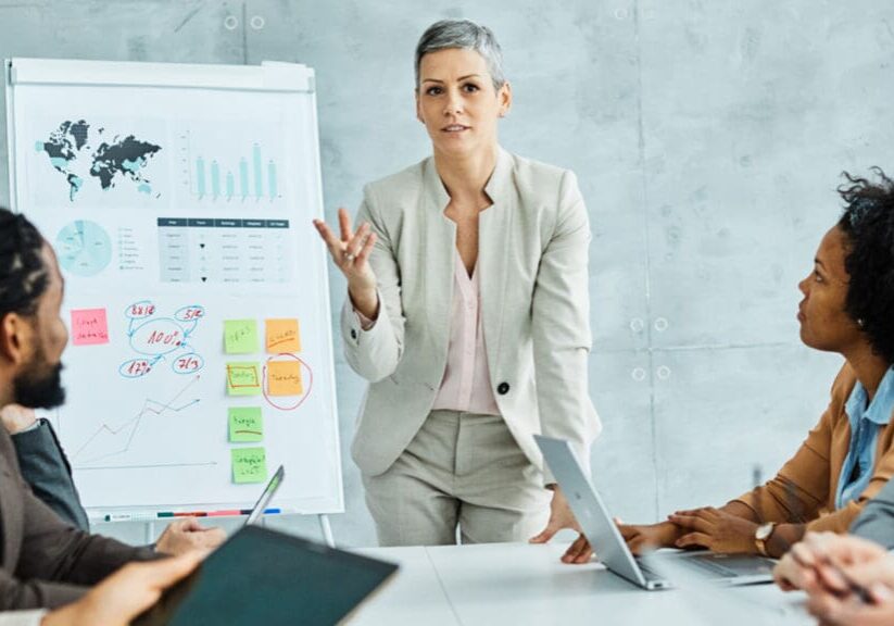 A woman standing in front of a board while holding her hand up.